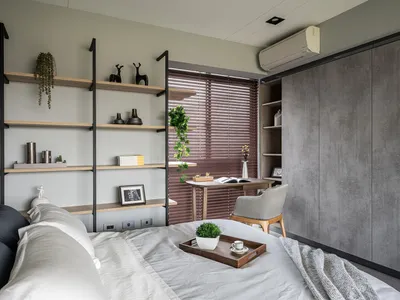 A minimalist bedroom featuring floating shelves, a cozy bed, and a desk area.