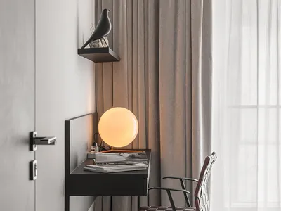 A modern home office with a wooden desk, leather chair, and globe lamp.