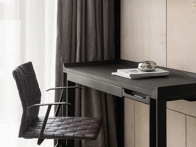A modern home office with wooden furniture, featuring a desk, chair, and decorative bird figure on a shelf.