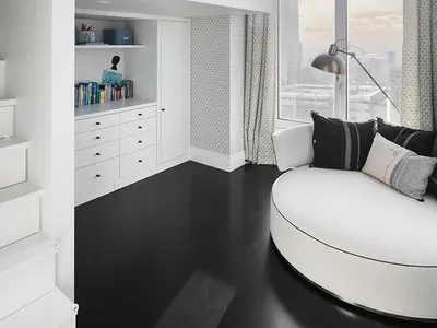 A modern bathroom featuring white concrete walls and floors, with a circular white bathtub and a white vanity cabinet.