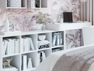 A contemporary home office features blush palm wallpaper, modern furniture, and white bookshelves filled with books and decor