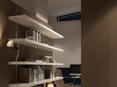 A modern home office with floating wooden shelves filled with books and decor.