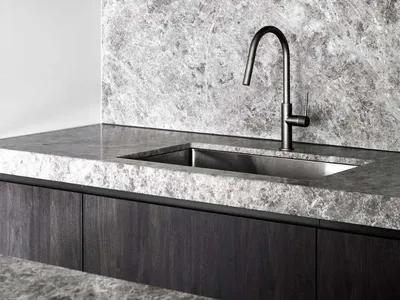 Contemporary kitchen featuring a sleek, minimalist design with dark wood cabinetry and a marble countertop and backsplash.