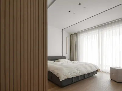 Minimalist bedroom with wooden walls and a comfortable bed.