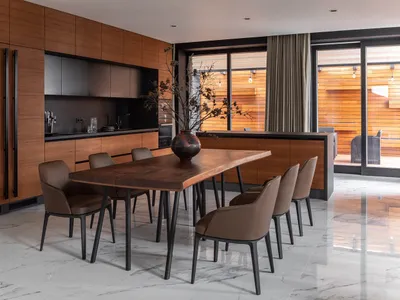 A modern residential kitchen featuring marble and wood finishes.