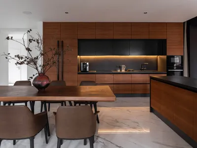 A modern residential kitchen featuring wood accents and marble countertops.