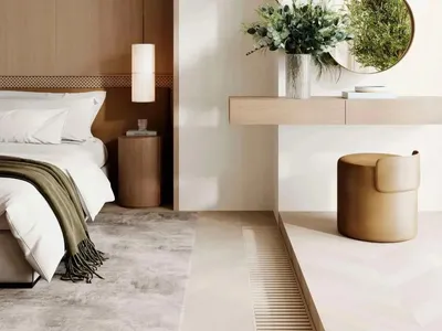 A minimalist bedroom featuring a wooden headboard and a white bed with green throw blanket.