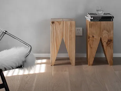 Two modern Scandinavian side tables made of light-colored wood in a living room setting.