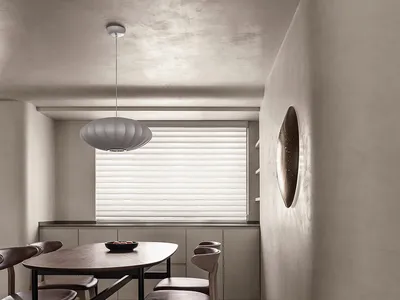 A minimalist kitchen with a wooden dining table and concrete flooring.