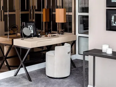 A modern home office featuring a sleek desk, round chair, and decorative elements.