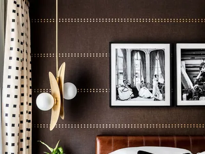 A modern minimalist bedroom with a brown leather headboard, white bedding, and a stylish plant on the nightstand.