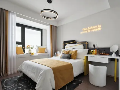A modern bedroom with a neutral color scheme accented by yellow elements, featuring a comfortable bed, stylish desk, and a po
