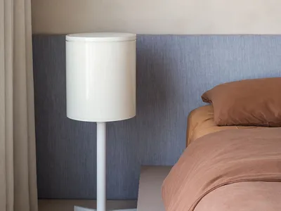 Modern minimalist bedroom with a bedside lamp, curtains, and soft lighting.