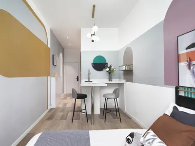 A minimalist bedroom featuring geometric wall art and a low-profile bed with a single decorative pillow.