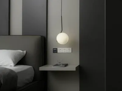 Minimalist bedroom with a metal floating light above a bed.