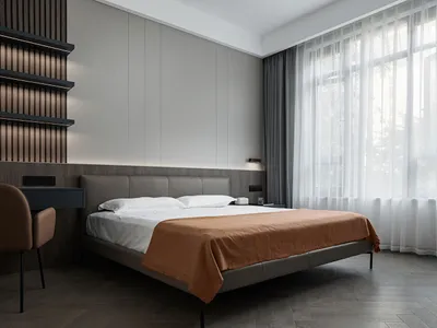 A contemporary minimalist bedroom with a bed dressed in brown blankets and a white bedspread, featuring woven curtains, woode