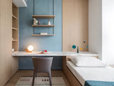 A minimalist bedroom with a marble desk, wooden shelves, and a single bed.