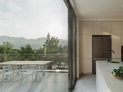 Modern kitchen with marble countertops and white appliances, featuring a contemporary design aesthetic.