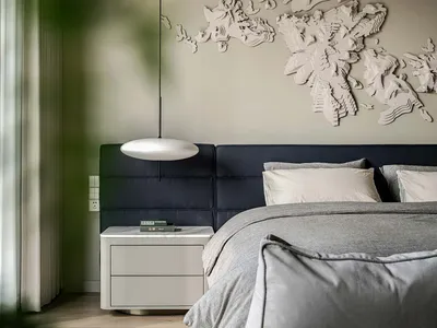 A modern minimalist bedroom featuring a fabric headboard and a wall-mounted decorative world map.