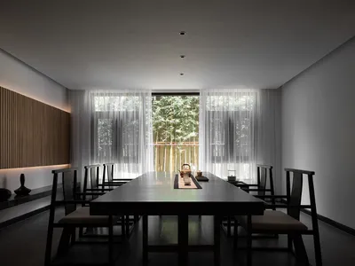 現代簡約餐廳用餐區，設有長桌、座椅及茶道擺設。