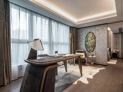 A modern home office featuring a wooden desk, leather chair, and luxurious interior design elements.
