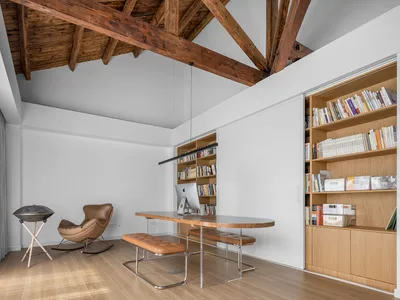 Minimalist home office featuring a wooden desk and bookshelf.