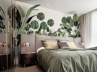 A bedroom featuring a modern bed with green bedding and a wall adorned with plant leaves.