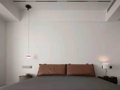 Minimalist bedroom with leather accents and a modern pendant light fixture.