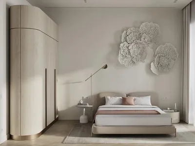 A bedroom with a neutral color palette featuring a bed, nightstand, and decorative wall art.