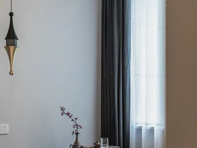 Minimalist bedroom with a wooden trunk decorated with tea set and vase.