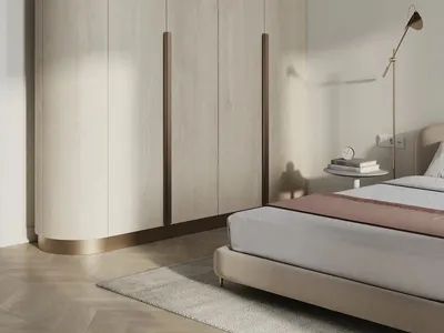Modern minimalist bedroom with wooden cabinets and a beige upholstered bed.