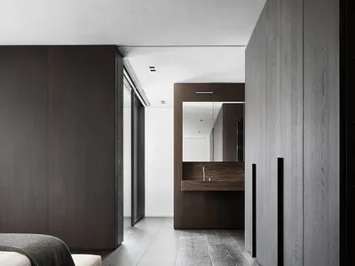 Modern bedroom suite with gray wood flooring and a concrete countertop, featuring a white bed.