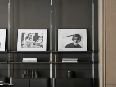 A modern industrial living room with a white leather couch, black shelves, and black and white wall art.