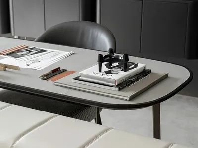 A modern home office space featuring a sleek, minimalist desk, contemporary black and gray furnishings, and a black and white