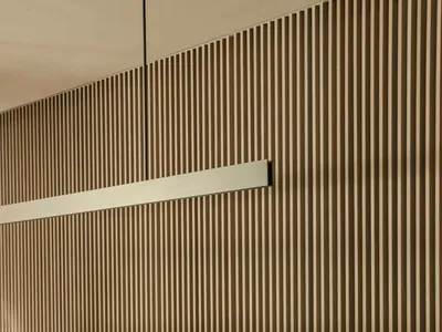 Modern minimalist restaurant interior featuring a wooden table and chairs against a wooden panel wall.