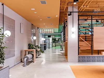 Industrial-style restaurant interior featuring concrete walls, metal accents, and wooden elements.