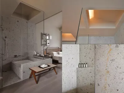 Modern bedroom with concrete walls and floor, featuring a double bed and minimalist decor.