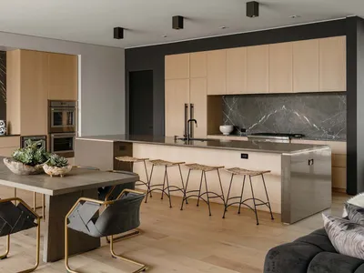 Modern residential kitchen featuring wooden cabinets and a marble backsplash.