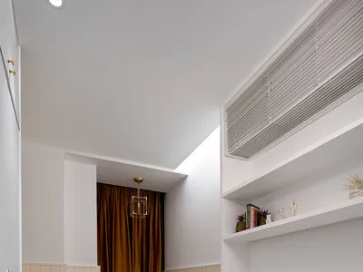 Modern minimalist bedroom featuring white and yellow decor with built-in desk and cabinetry.