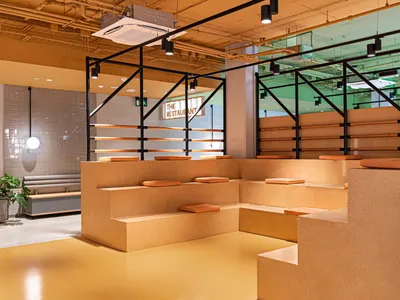 現代工業風餐廳用餐區，融合混凝土、磚牆與木質元素