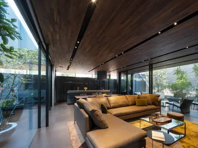 Industrial-style living room with wooden walls, leather couches, and a modern design.