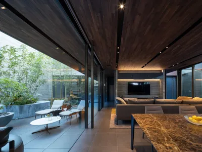Industrial minimalist living room featuring wood, concrete, and masonry materials.