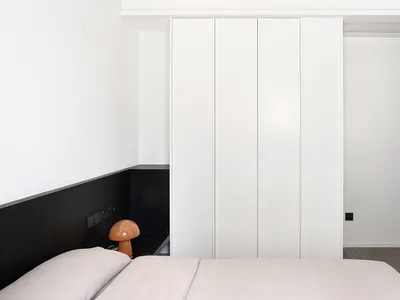 A modern minimalist bedroom with white panels on the wall.