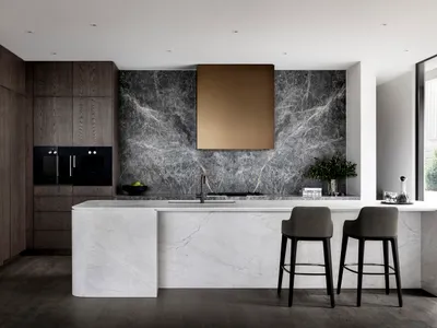 Contemporary residential kitchen featuring dark wood cabinets, a marble backsplash, and a marble kitchen island.