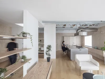 A minimalist residential kitchen with wooden surfaces and modern design elements.