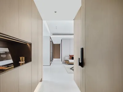Modern bathroom with white walls, wooden cabinets, and a sleek minimalistic design.
