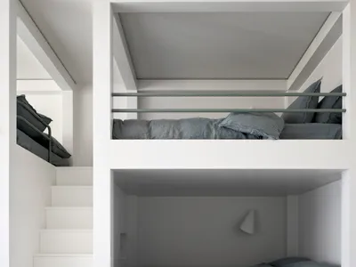 A modern minimalist bedroom with white walls and wooden bunk beds