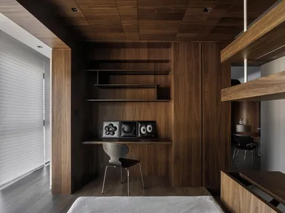 A minimalist home office with wooden shelves and a sleek workspace.
