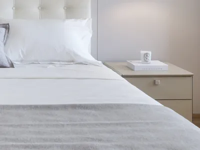A minimalist bedroom with a white upholstered bed