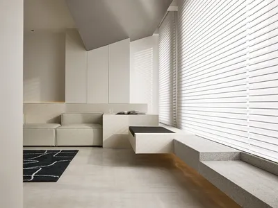A minimalist living room featuring a concrete floor, a white angular sofa, and white walls with a large window.